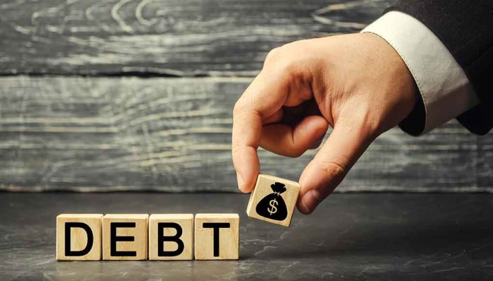 Hand replacing debt block with money symbol block