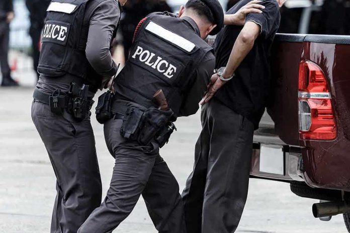 Police officers arresting a handcuffed person