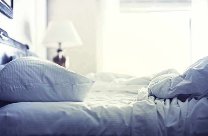 shutterstock_197128130.jpg A cozy unmade bed with soft pillows and bedding in a well lit room