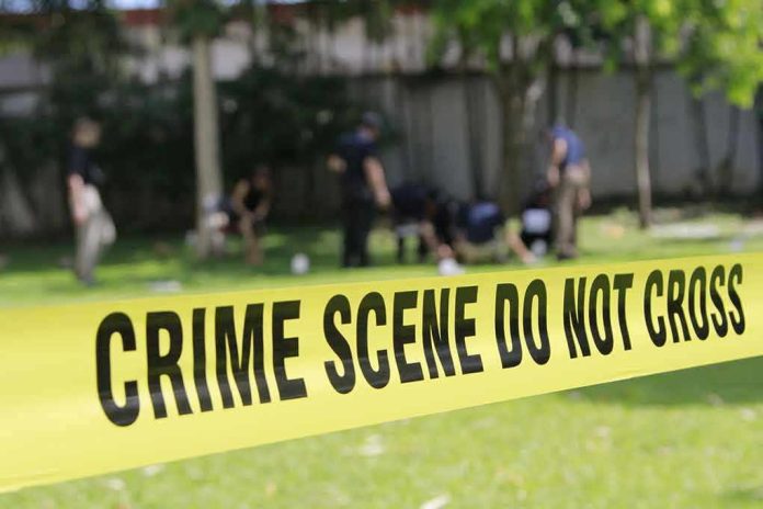 308657879 Yellow crime scene tape blocking grassy area.
