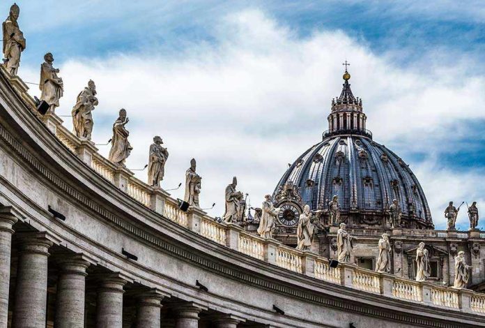 368201633 St. Peters Basilica dome with statues and clouds.