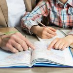 Man and child studying map together at table