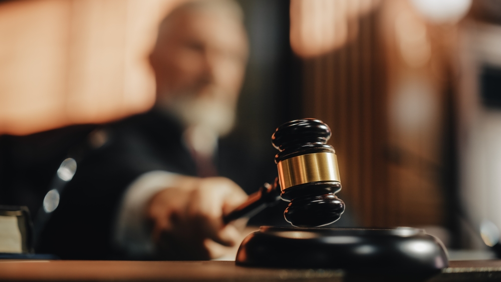 Judge with gavel in courtroom setting blurred background