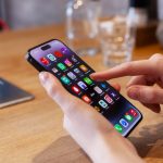 Person using smartphone with colorful app icons displayed