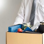 Person holding a box of personal office items.