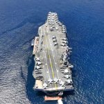 Aircraft carrier on open sea with parked planes