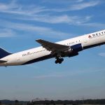 Delta Airlines airplane taking off against a blue sky