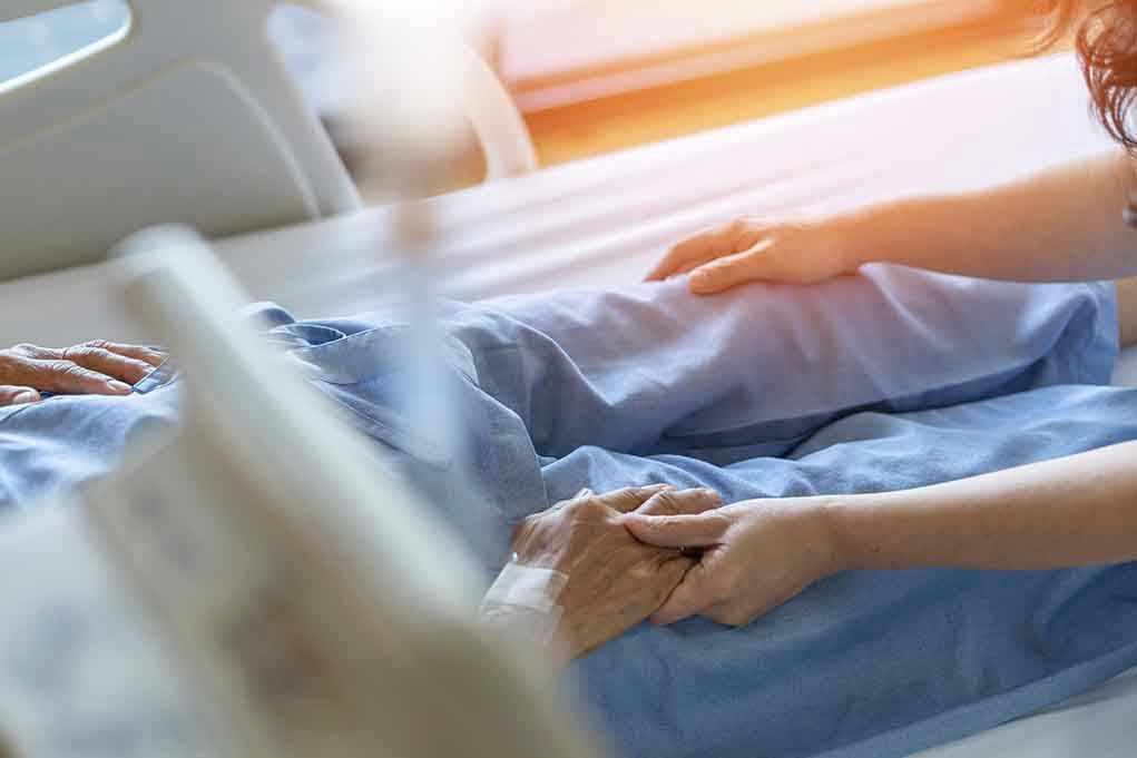 1921764251 Hospital patient holding visitors hand reassuringly