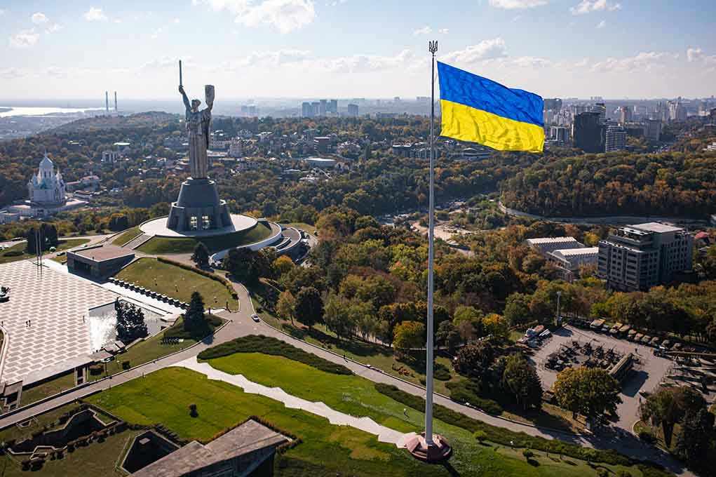 2057020673 Large Ukraine flag with cityscape in background