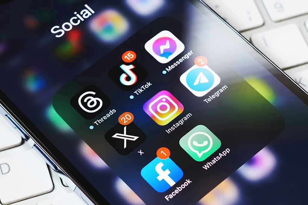 2339442245 Smartphone showing social media app icons in a folder.