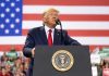 Trump SLAMS Foreign Leader—Cuts Funding! Man speaks at podium with U.S. flag background.