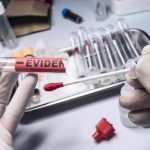 Gloved hands holding evidence tube and cotton swab.