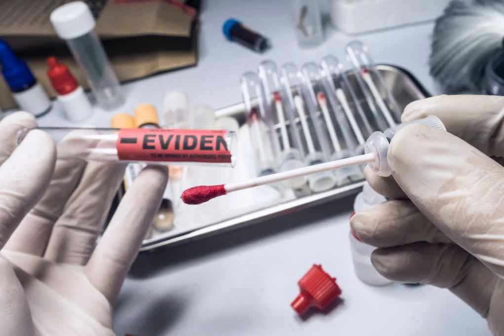 1701288700 Gloved hands holding evidence tube and cotton swab.