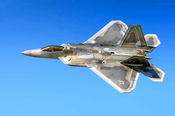 514318066 Fighter jet in flight against a clear blue sky.