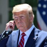 World Leader RIPS Trump – Tectonic Shift in Relations Man in a suit adjusting an earpiece.