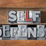 Self-Defense Law SHATTERED by Fatal Mistake Metallic block letters spelling SELF DEFENSE on wooden shelves.