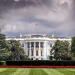 TROOPS SHOT Near White House – Political FURY Erupts White House front view with dark clouds above.