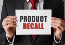 Product Recall sign held by person in suit.