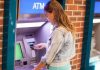 $124 Trillion Up for Grabs—Who Gets Left Out? Young woman using an ATM in an urban environment