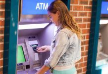 $124 Trillion Up for Grabs—Who Gets Left Out? Young woman using an ATM in an urban environment