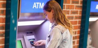 Young woman using an ATM in an urban environment