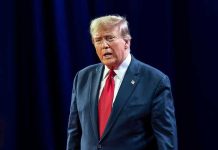 Trump SIEZES Venezuela Tanker – Sparks High-Seas Showdown Man in suit with red tie speaking on stage.