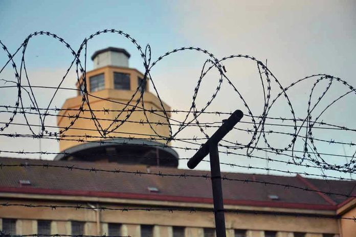 Barbed wire in front of a prison tower.