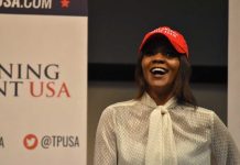 Candace Owens BLASTS Kirk’s Widow – Issues WILD Theory A woman wearing a red cap and a white blouse speaking at a political event