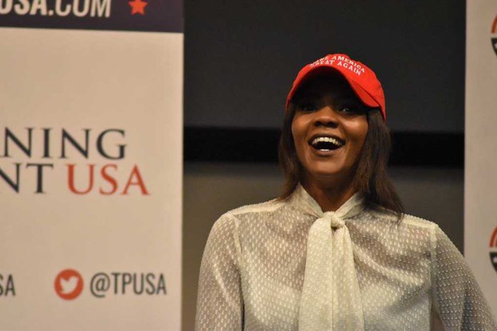 shutterstock_1232508253.jpg A woman wearing a red cap and a white blouse speaking at a political event