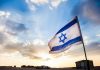 Eurovision Firestorm Erupts – Major Countries BOYCOTT Event Israeli flag waving against a sunset backdrop with clouds