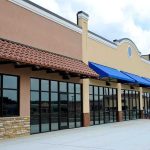 Iconic Restaurant VANISHES – Gone After 88 Years! Exterior view of a commercial building with blue awnings and large glass windows