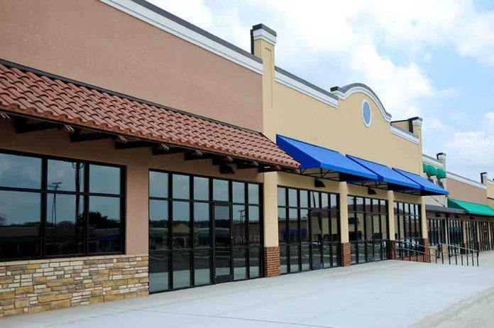 Exterior view of a commercial building with blue awnings and large glass windows