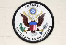 Seal of the United States Embassy featuring an eagle and the American flag