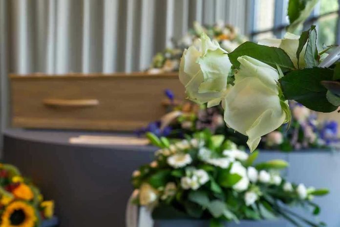 White roses in front of a casket.