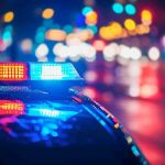 Police car with flashing lights at night.