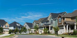 Governor Wants To REMOVE Property Taxes! Suburban street with colorful, modern houses.