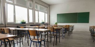 SICKO Teacher Humiliates Boy With Trash Can Empty classroom with desks, chairs, windows, and chalkboard.