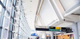 Travel Chaos – DHS Pull Staff From Sanctuary Airports! People walking in a brightly lit airport terminal.