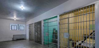 ICE Suicide Deaths SURGE After Massive Failure Interior view of a prison cell block with metal bars and concrete flooring