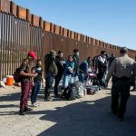 Trump Hits HISTORIC Milestone- 13 Months Straight! Border patrol agents interact with a group of people.
