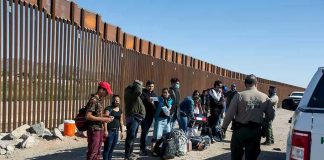 Border Tunnel BUSTED Under ‘Storefront’! Border patrol agents interact with a group of people.