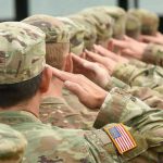 National Guardsman GUNS DOWN Colleague After He Saw THIS! Soldiers in uniform saluting, American flag patch visible.