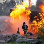 Hero Firefighter CAUGHT Igniting Town On Fire! Firefighter battling a large fire with water spray