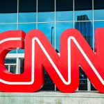 Dem Senator TORCHES CNN Host On-Air! Large red CNN logo in front of a glass building