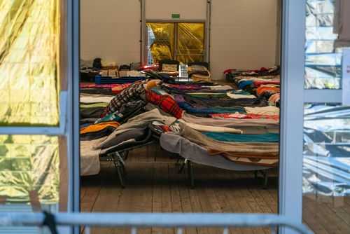 Interior view of a temporary shelter with rows of beds.