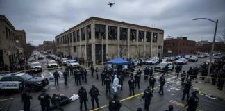 Police officers and FBI agents at a crime scene with a drone overhead
