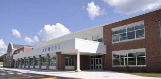 Graduation Chaos – Shooter GUNS-DOWN Ceremony! Modern school building with large windows and a clear sky