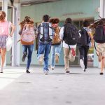 Schools Hide Kids’ Identities — Parents SUING! Children running with backpacks outside a school building.