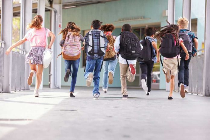 Children running with backpacks outside a school building.