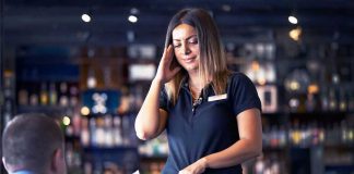 Person receiving money from customer in a bar